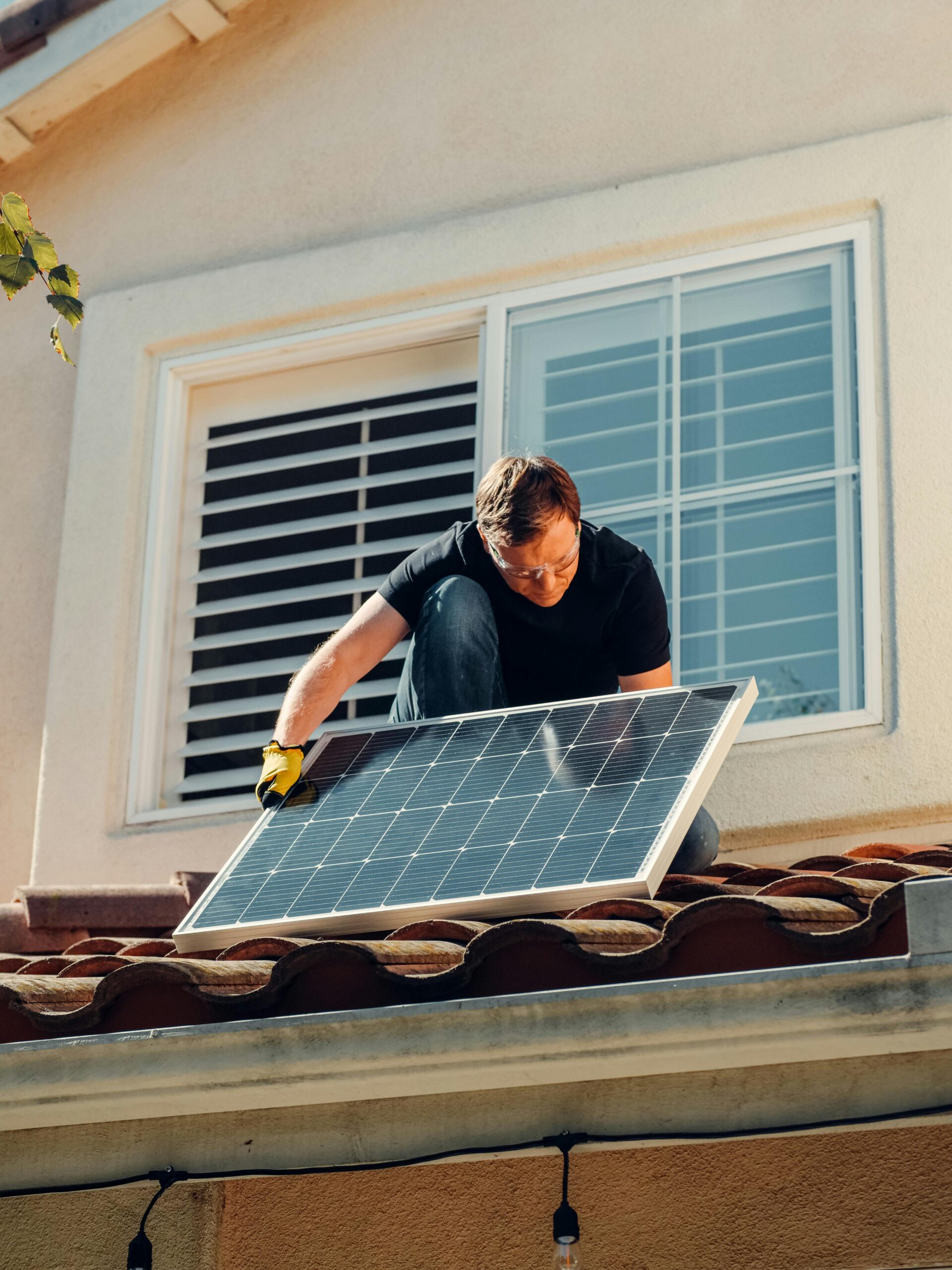 homme qui installe un panneau photovoltaïque